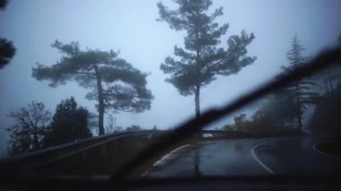 Yolculuk sırasında yol kenarında sürüş araba pitoresk doğası ile yağmurlu sisli yolun görünümü. Kıbrıs. Yavaş çekim.