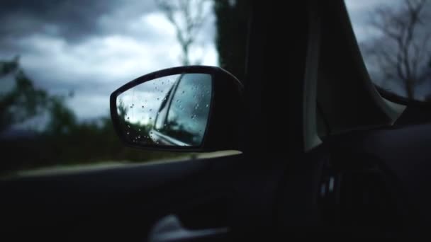 Reflectie van regenachtige avond straat in de zijspiegel van een bewegende auto langs de herfst mooie weg tijdens het reizen. Cyprus — Stockvideo