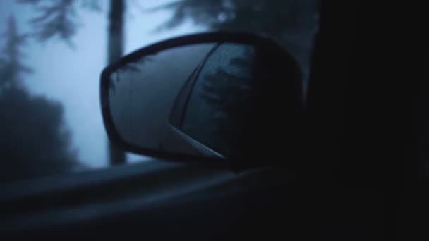 Reflection of rainy evening street in the side mirror of a moving car driving in a small mediterranean town. Foggy road. Traveling. Cyprus. Slow motion. — Stock Video