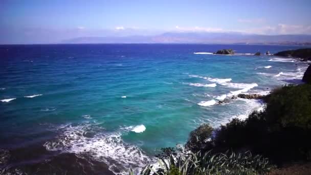 Uitzicht op de schilderachtige kust met blauwe lucht en creëren door heldere golven van de zee op zonnige zomerdag. Cyprus. Slow Motion. — Stockvideo