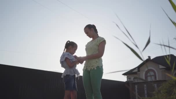 Mama i jej mała córka stoi na ulicy w letnim wieczorem i rozmawia serce z miłością. Relacja Mama i córka. Prawdziwa szczęśliwa Rodzina. — Wideo stockowe