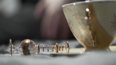 Sarı desenli yaldızlı bir kase masanın üzerinde, yanında aynı şişe. Büyülü öğeler ve eylemler. Geleneğin güzelliği