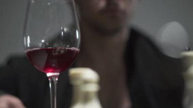 Tanınmayan bir adamın şarap kadehinden kırmızı şarap içen portresi. Genç adamın eğlence.