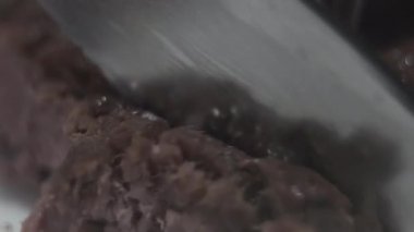 Koyu dilimlenmiş kuzu eti veya buzağı eti keskin gümüş seramik bıçak ile kesme tat olacak. Yakın çekim