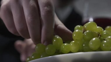 Tanınmayan işadamı yakından üzüm yiyor.