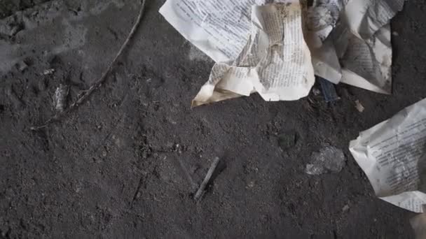 Pagine di libri stropicciati si trovano sul pavimento di cemento di un edificio abbandonato. Il bicchiere di vino cade a terra e si rompe. Concetto di distruzione — Video Stock