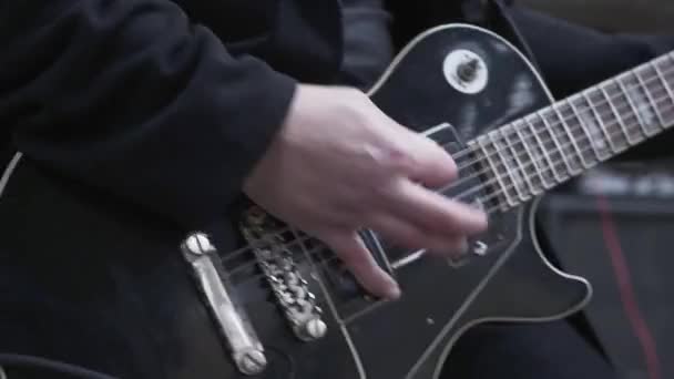 El hombre seguro toca la guitarra eléctrica. Banda de rock haciendo música — Vídeo de stock