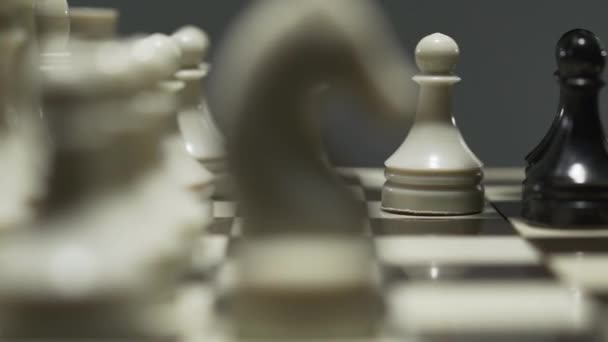 Gros plan de l'échiquier avec des pièces d'échecs blanches et noires. Lors d'un tournoi tendu, l'adversaire prend un pion .