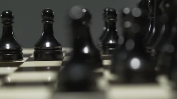 흰색과 검은 색 체스 조각 체스 보드. 긴장된 토너먼트에서 상대는 폰을 잡습니다. 클로즈업 — 비디오