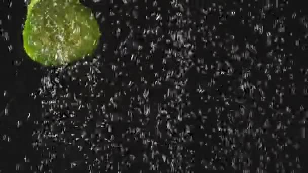 Komkommer en tomaten plakjes spetteren in het water op een zwarte achtergrond. Verse groente in het water met bubbels. Biologisch voedsel, gezonde levensstijl, dieet. Slow Motion. Video met versnelde. — Stockvideo