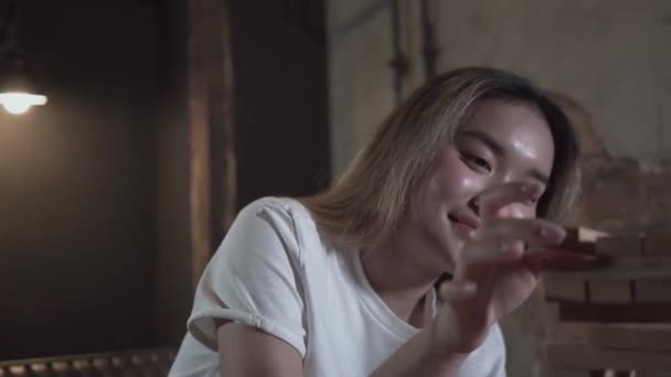 Mujer joven jugando bloques de madera torre en la habitación de estilo loft primer plano. Ocio en interiores. Chica despreocupada relajándose en la sala de juegos . — Vídeos de Stock