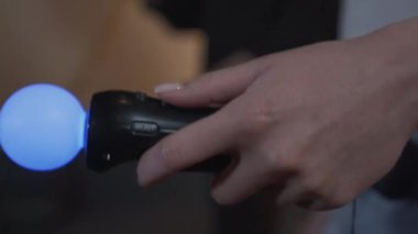 Oyun odasında dans eden iki arkadaş. Kadın el parlak hareket sensörü yakın çekim tutarak. Mutlu çift birlikte vakit geçiriyor. İç mekanlarda boş zaman