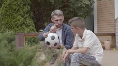 Baba ve oğlu verandada oturmuş elinde sönmüş bir futbol topu tutuyorlar. Adam ve çocuk futboldan bahsediyorlar. Aile birlikte vakit geçiriyor. Yaz eğlencesi, aktif yaşam tarzı