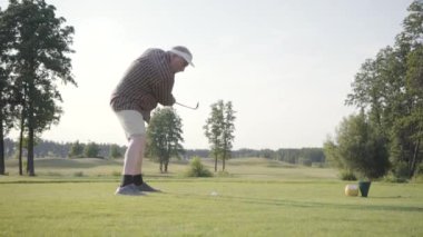 Portre başarılı olgun golfçü sallanan ve güzel ders Golf topu vurmak. Güneş ışığında ayakta güzel güneşli yaz havalarda kendine güvenen adam Golf.