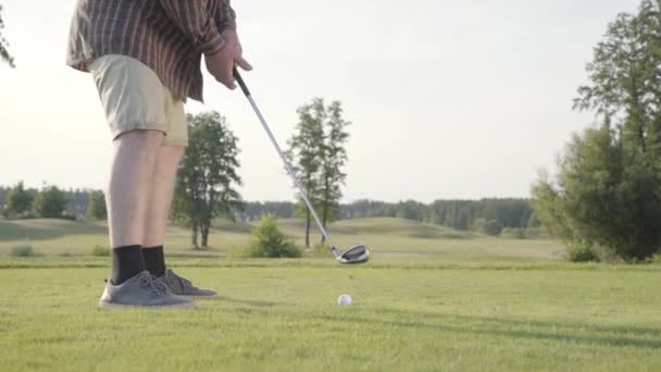 Nierozpoznany człowiek grający Golf uderzając piłkę golfową na pole golfowe. Koncepcja rekreacji i sportu na zewnątrz. — Wideo stockowe