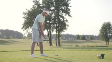 Portre yakışıklı başarılı Orta Doğu golfçü sallanan ve güzel ders Golf topu vurmak. Güneş ışığında ayakta güzel güneşli yaz havalarda kendine güvenen adam Golf.