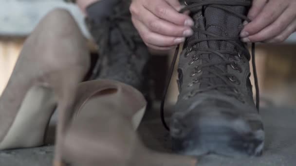 Primer plano de las manos de la joven mujer atando sus zapatos viejos preparándose para el entrenamiento. Zapatos de tacón alto tirados cerca. Concepto de chica fuerte — Vídeo de stock