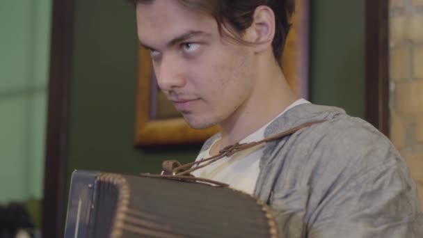 Jonge man speelt de accordeon. Vrolijke muziek op het oude instrument. Folk concept — Stockvideo
