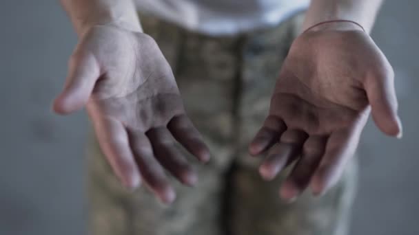 Close-up dirty hands of young woman in military uniform after training. The girl showing her palms to the camera. Concept of a strong soldier woman — Stock Video