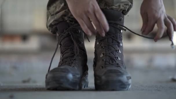 Close-up of female hands lacing up her old shoes getting ready for training. Warrior woman in a deserted factory. — Stock Video