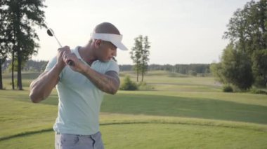 Portre yakışıklı başarılı Orta Doğu golfçü sallanan ve güzel ders Golf topu vurmak. Güneş ışığında ayakta güzel güneşli yaz havalarda kendine güvenen adam Golf.