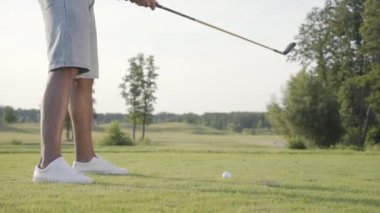 Golf sahasında golf oynayan tanınmayan bir adam. Emin adam ısınıyor ve bir Golf Kulübü kullanarak topa vurdu. Açık havada rekreasyon ve spor konsepti.