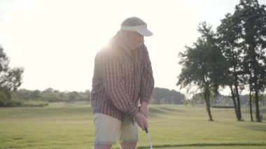 Portre başarılı olgun golfçü sallanan ve güzel ders Golf topu vurmak. Güneş ışığında ayakta güzel güneşli yaz havalarda kendine güvenen adam Golf.