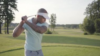 Portre yakışıklı başarılı Orta Doğu golfçü sallanan ve güzel ders Golf topu vurmak. Güneş ışığında ayakta güzel güneşli yaz havalarda kendine güvenen adam Golf.