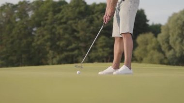 Golf sahasında golf oynayan tanınmayan bir adam. Emin adam ısınıyor ve bir Golf Kulübü kullanarak topa vurdu. Rekreasyon ve spor açık hava kavramı. Yavaş hareket