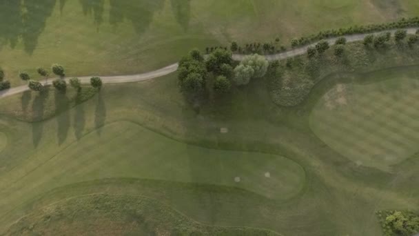 Flygfoto av stor lyxig golfbana. Utsikt över de gröna gräsmattorna och träden. Skytte ovanifrån, ovanifrån, drönarskytte. — Stockvideo