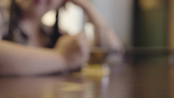 Figure floue de femme avec des nattes assises au comptoir du bar avec un verre de bière. Les mains des hommes clignent des verres d'alcool à moitié vides en gros plan. Rencontre avec des amis au bar — Video