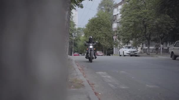 Erkek veya kadın bir motosiklet kıyafeti bir şehir yolu boyunca bir Biker motosiklet sürme giyiyor. Boş bisikletçi. — Stok video