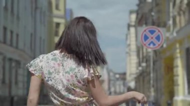 El alışveriş çantaları ile Carefree genç kadın eski Avrupa şehir etrafında yürüyüş, dans ve etrafında Spinning, kulaklıklar müzik dinlerken. Mutlu kız Leisure