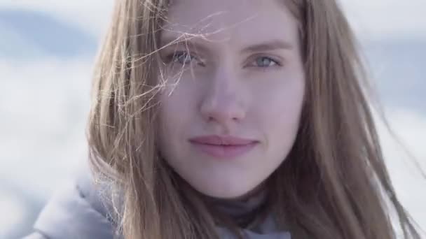 Close-up retrato de bela jovem loira com cabelos longos e olhos azuis olhando para a câmera. Mulher atraente de aparência escandinava na geleira — Vídeo de Stock