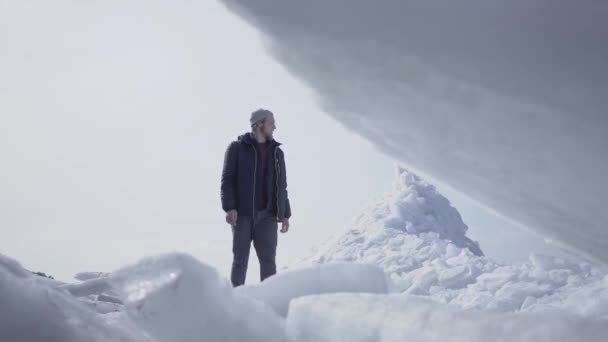 Adam buzulda yürüyor. Karlı bir Kuzey veya Güney Kutbu muhteşem görünümü. Ön planda buz blokları yakın. Soğuk güzellik — Stok video