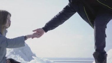 Yakışıklı sarışın sakallı adam ona buz bloğu tırmanmaya yardım çekici genç kadına el veren. Buzullarını keşfeden birkaç turist. İnsanlar sarılıyor