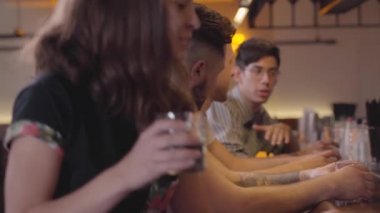 Üç yetişkin adam barın tezgahında oturmuş konuşuyor. Çekici kız yanında oturan ve onun cam yükselterek. Rahat arkadaşlar birlikte elit alkol içme ürpertici. Gün izin