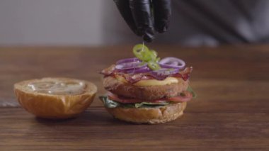 Burger yakın çekim yapan şefin elleri. Lezzetli yemek hazırlama.