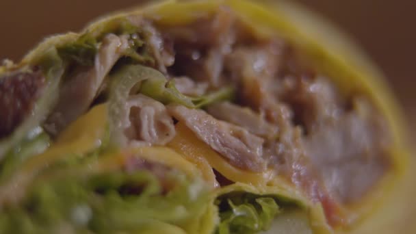 Gros plan de shawarma coupé avec viande, oignon, laitue, tomates roulées dans une pita. Le tournage détaillé de la collation arabe ou turque — Video