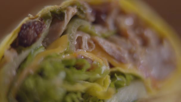 Apropierea shawarmei tăiate cu carne, ceapă, salată verde, roșii laminate într-o pita. Fotografierea detaliată a gustării arabe sau turcești — Videoclip de stoc