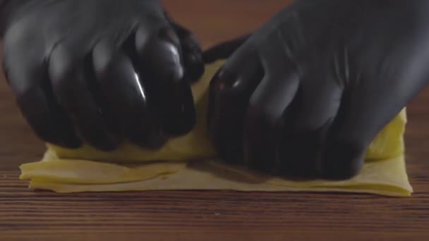 Zbliżenie rąk szefa umiejętności w czarnych rękawiczkach gumowych co Shawarma. Cook walcówka Szałarma w Pita na drewnianej płycie. Smaczne przygotowanie przekąskę. Zwolnionym. — Wideo stockowe