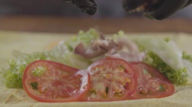 Shawarma yakın çekim yapma siyah mutfak eldivenleri şefin elleri. Pide üzerine domates ve soğan üzerine sulu et koyarak pişirin. Lezzetli arap çerez hazırlık. Yavaş çekim.