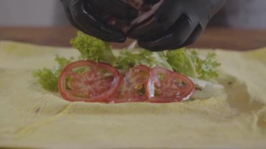 Shawarma yakın çekim yapma siyah mutfak eldivenleri şefin elleri. Lezzetli arap çerez hazırlık. Yavaş çekim.