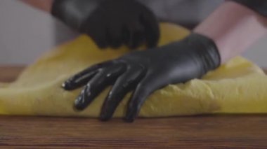 Shawarma yakın çekim yapma siyah lastik eldiven şefin elleri. Aşçı tahta tahtadaki pidede shaurma yuvarladı. Lezzetli atıştırmalık hazırlığı. Yavaş çekim.