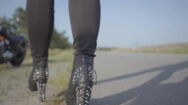 Siyah ayakkabılı tanınmayan motosikletçi motosiklete gelir. Hobi, seyahat ve aktif yaşam tarzı. Onu motosiklet açık havada kadın bisikletçi.