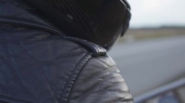 Siyah deri ceket ve kask tanınmayan motosiklet sürücüsü açık havada bir motosiklet üzerinde oturan. Hobi, seyahat ve aktif yaşam tarzı. Motosikletle eğlence ve seyahat