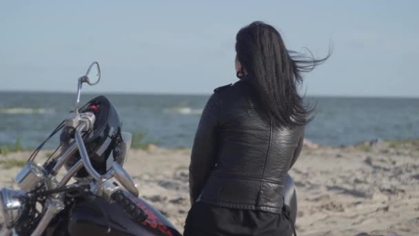 Nehir kıyısında ki motosikletin üzerinde oturan beyaz kızın arka görünümü. Hobi, seyahat ve aktif yaşam tarzı. Motosikletle eğlence ve seyahat. — Stok video