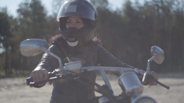 Retrato mujer linda con casco negro sentado en la motocicleta mirando hacia otro lado. Hobby, viajar y estilo de vida activo. Motociclista en su moto al aire libre. Ocio y viajes en moto. Luz suave . — Vídeo de stock