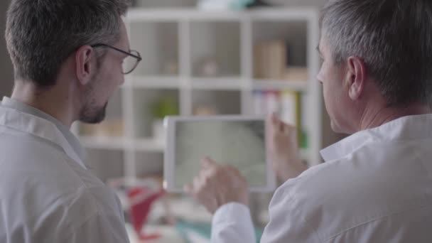 두 기술 경험 남성 의사 태블릿에 폐의 엑스레이를 확인, 토론. 의학, 건강 관리 및 사람, 병원의 개념. 새로운 현대 완전 기능 의료 시설. — 비디오