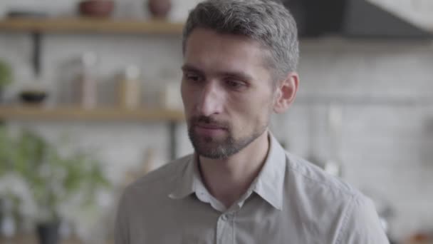 Portrait de type barbu regardant avec confiance la caméra profiter du mode de vie exécutif sur le fond d'une cuisine moderne. Série des personnes réelles — Video